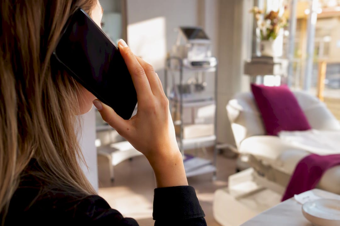 Notwendigkeit von Kundengewinnung: Warum sie überlebenswichtig ist 4 Eine Hand hält das Smartphone bereit für ein Beratungsgespräch mit einer Kundin aus dem Kosmetikbereich.