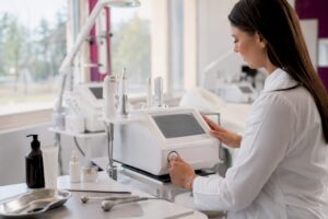 Hand, die die Bedienelemente eines ästhetischen Geräts einstellt