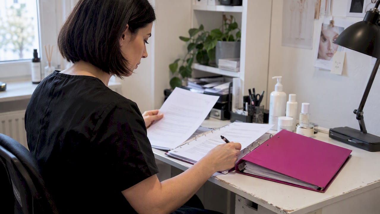 Kosmetikerin überprüft Produktdokumentation im Studio